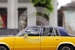 Yellow classic American car with a black roof
