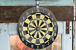 Yellow classic darts board on the old window