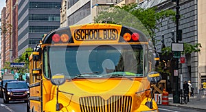 Yellow classic public school bus on the street, New York, Manhattan downtown