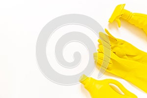 Yellow cleaning kit. Bottles and rubber gloves flat lay on the white background with copy space.