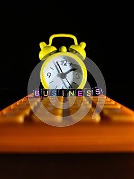 Yellow clock and business word