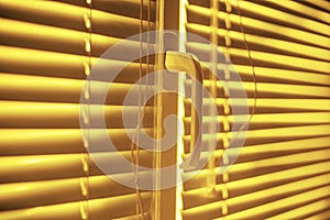 Yellow closed horizontal blinds with rope and handle. Perspective view, closeup