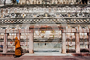 Yellow clothing monk walk past the stone temple