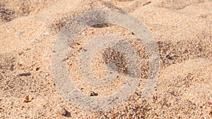 Yellow coarse sand on the beach by the sea