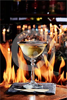 Yellow cocktail based on white wine in a beautiful goblet glass on copper designer bar counter, the background of real