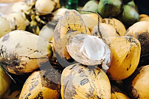 Yellow coconuts are sold in the market of the island of Mauritius. Cut a young coconut with Makoto. Many coconuts on the market