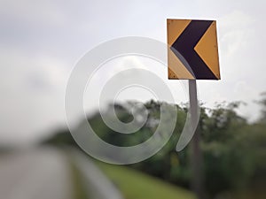 Yellow color left curve sign plate at the highway