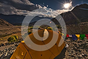 Yellow color tent being set up by trekkers for night stay in ladakh