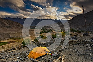 Yellow color tent being set up by trekkers for night stay in ladakh