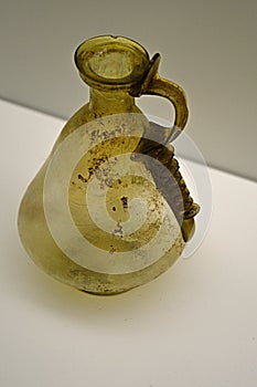Yellow coloured ancient glass jugglet with ribbed handle, conical shape, possibly from Cyprian manufactures