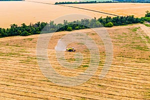 Yellow combines harvests wheat on the field.