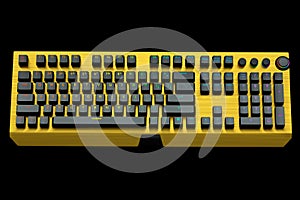 Yellow computer keyboard with rgb colors isolated on black background.