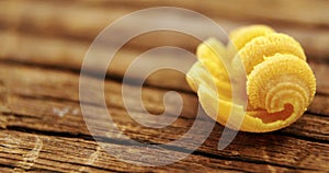 Yellow conchiglie pasta on wooden table