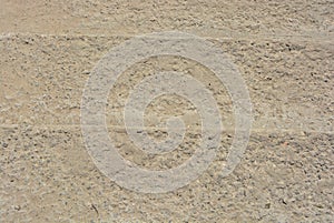 Yellow concrete background of gravel and sand, concrete steps.