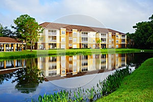 Yellow condos or apartments and a small pond