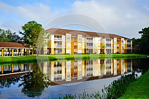 Yellow condos or apartments and a small pond