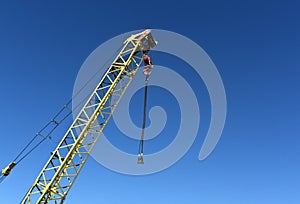 Yellow construction crane and blue sky.