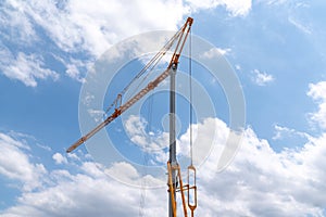 Yellow construction crane on building site in the blue sky
