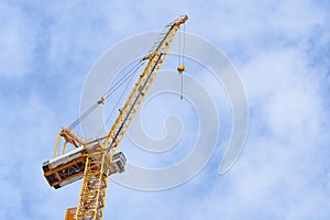 Yellow construction crane on bule sky background