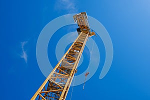 Yellow construction crane isolated on blue sky background