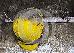 Yellow construction helmet hanging on hat rack.