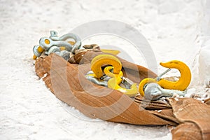 Yellow construction hooks and slings for unloading cargo and loading cargo lie on the snow.