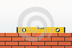 an yellow construction level on brick wall