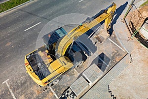 A yellow construction vehicle is parked on the side of a road, ready for work
