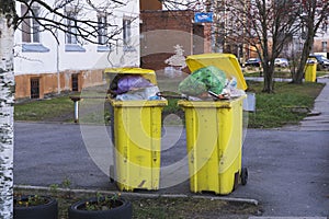 Yellow containers with household garbage in the courtyard of an apartment building