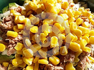 Yellow corn and pink tuna for salad, food background