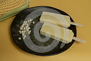 Yellow corn popsicles melting in the plate