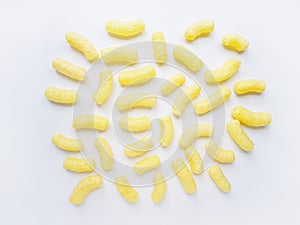 Yellow corn sticks in a white plate on a white background.