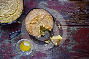 Yellow Cornbread in cast iron skillet on rustic wood table top view