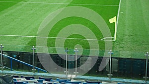 A yellow corner flag waving in the wind on a football field