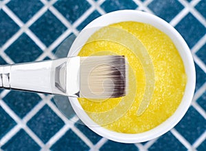 Yellow cosmetic mask (scrub) in a bowl