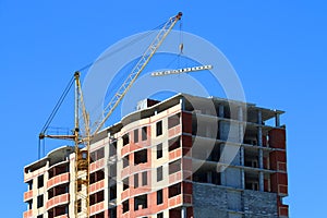 Yellow crane and brick building under construction