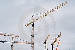 Yellow cranes against the blue sky. Construction background.