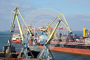 Yellow cranes and container ship in Odessa sea port,Ukraine