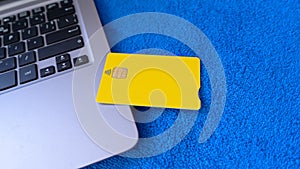 Yellow Credit Card On Laptop Computer Keyboard.Consumer making an Online shopping and purchase in internet paying with debit card