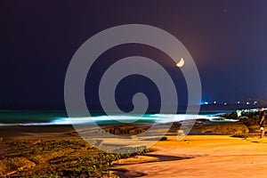 Yellow crescent moon above a stunning beach