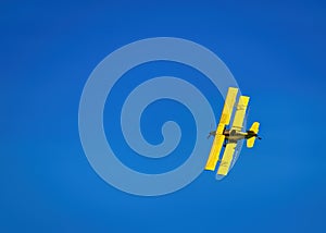 Yellow Crop Duster against a blue sky