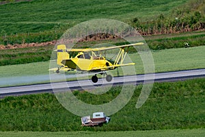 Yellow crop duster and pickup truck in farmland