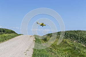 Yellow Crop Duster Spraying Pestisides On Crops