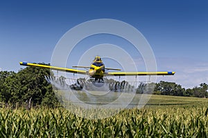 Yellow Crop Duster Spraying Pestisides On Crops