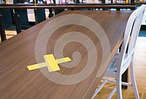 Yellow crosses labelled on the table . safe distancing rules in restaurants in Bangkok