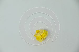 Yellow crumpled paper ball on a white background