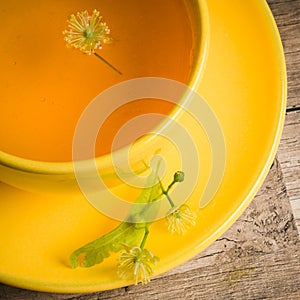 Yellow cup with linden tea , top view