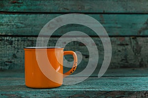 Yellow cup on the old wooden blue background