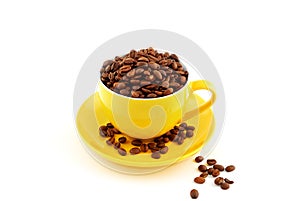 Yellow cup with saucer full of coffee beans