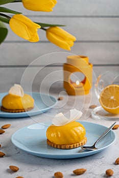 Yellow cupcakes and cup of coffee with yellow tulips on concrete background. Tasty morning dessert